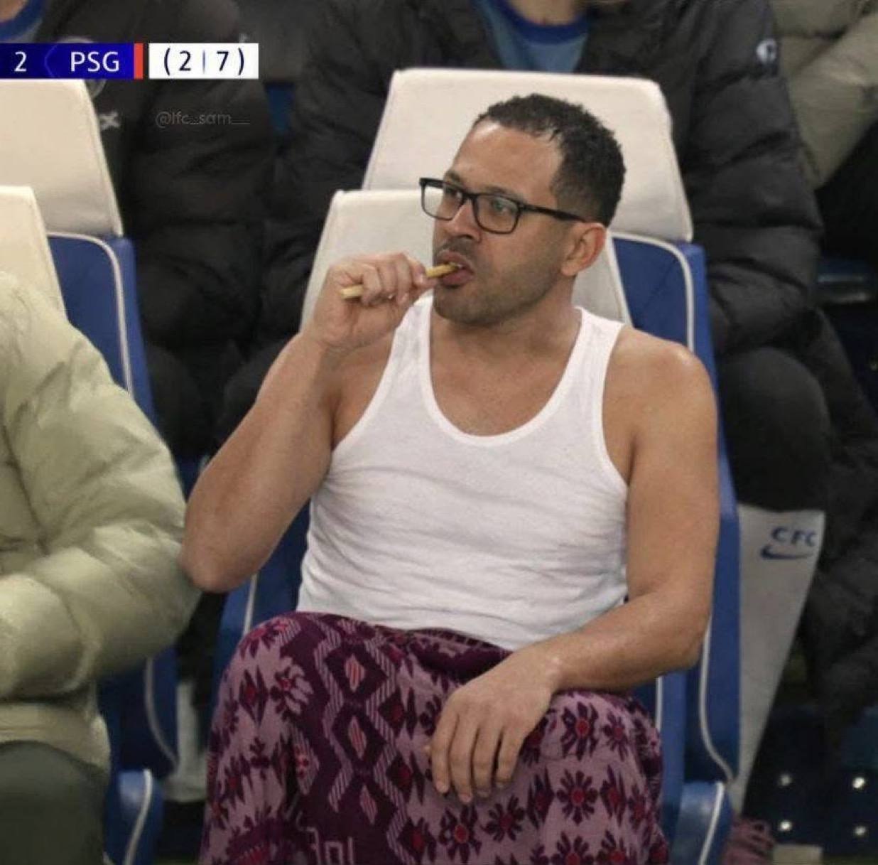 a man sitting in a stadium with a cigarette